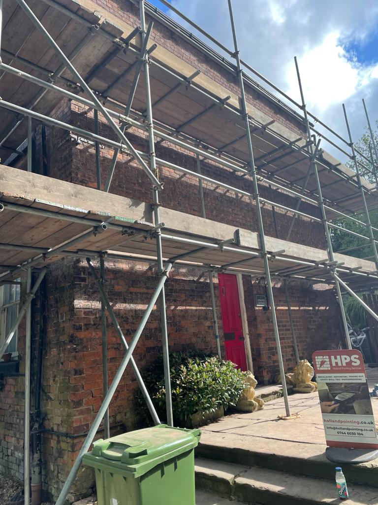 house with scaffolding being repointed
